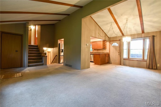 unfurnished living room featuring beamed ceiling, stairway, high vaulted ceiling, and light colored carpet
