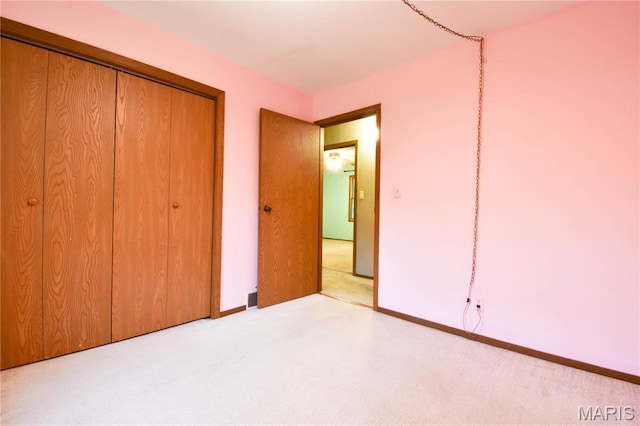 unfurnished bedroom with carpet flooring, a closet, and baseboards
