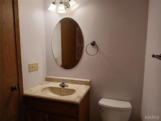 bathroom featuring a chandelier, toilet, and vanity