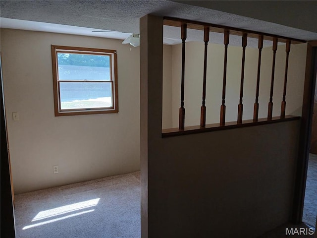 stairs with carpet floors and a textured ceiling