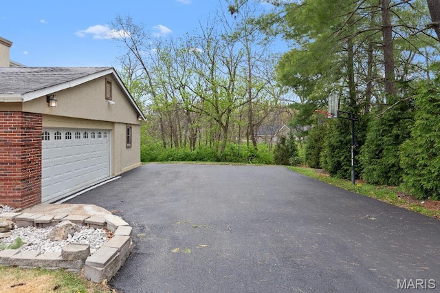 625 Pinebrook Dr, Town And Country, MO 63017 - view of home's exterior featuring a garage, asphalt driveway, and brick siding