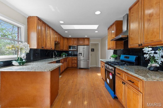 625 Pinebrook Dr, Town And Country, MO 63017 - kitchen with appliances with stainless steel finishes, wall chimney range hood, a skylight, light stone countertops, and decorative backsplash