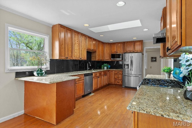 625 Pinebrook Dr, Town And Country, MO 63017 - kitchen featuring stainless steel appliances, a skylight, ventilation hood, light stone counters, and tasteful backsplash