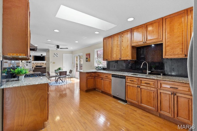 625 Pinebrook Dr, Town And Country, MO 63017 - kitchen with stainless steel dishwasher, light wood finished floors, a skylight, a sink, and brown cabinets