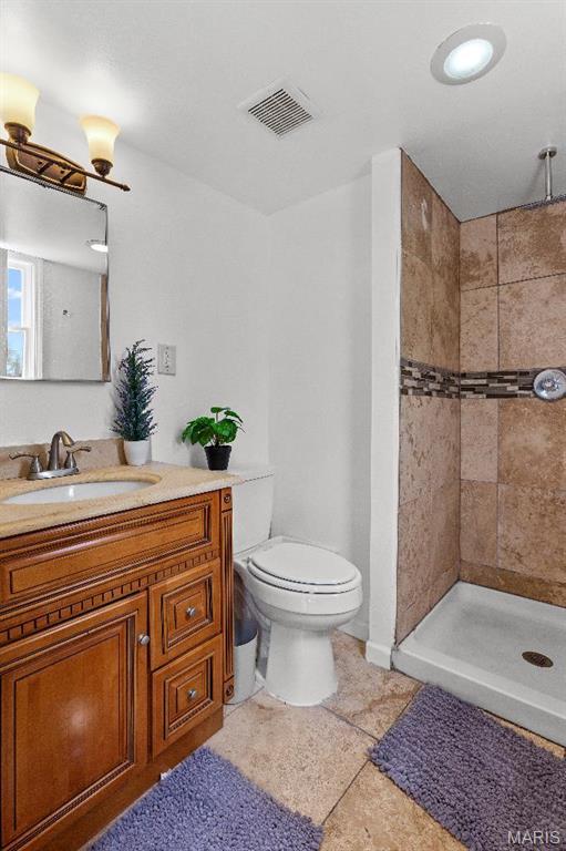 625 Pinebrook Dr, Town And Country, MO 63017 - full bathroom featuring tiled shower, vanity, toilet, and baseboards