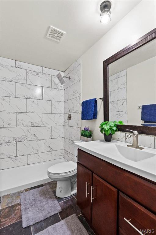 625 Pinebrook Dr, Town And Country, MO 63017 - bathroom featuring tiled shower, vanity, and toilet