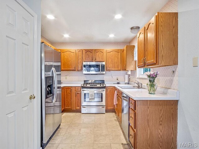 109 Miller Ct, Valmeyer, IL 62295 - kitchen with stainless steel appliances, a sink, decorative backsplash, light countertops, and brown cabinets