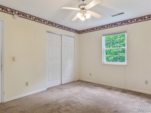 109 Miller Ct, Valmeyer, IL 62295 - unfurnished bedroom with carpet, a textured ceiling, a closet, baseboards, and a ceiling fan