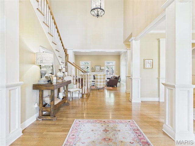 262 Woodland Hill Rd, Poplar Bluff, MO 63901 - foyer entrance with stairway, a towering ceiling, decorative columns, wood finished floors, and baseboards