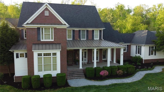 262 Woodland Hill Rd, Poplar Bluff, MO 63901 - view of front facade featuring a standing seam roof, covered porch, a shingled roof, and metal roof
