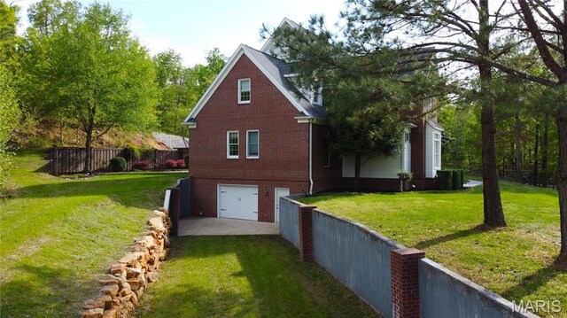 262 Woodland Hill Rd, Poplar Bluff, MO 63901 - view of property exterior with brick siding, an attached garage, and driveway