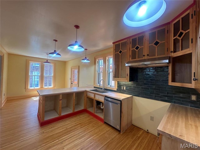 kitchen featuring dishwasher, a sink, light wood finished floors, a peninsula, and healthy amount of natural light
