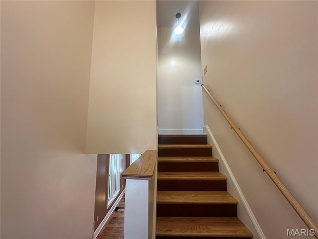 staircase with baseboards and wood finished floors