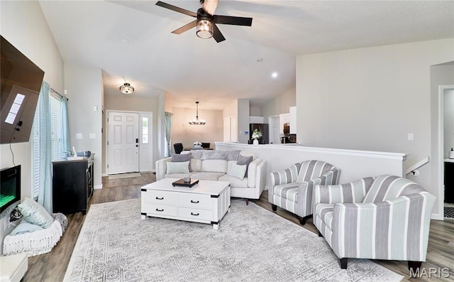 10 Warshire Ct Unit 67B, Ofallon, MO 63366 - living room featuring lofted ceiling, a ceiling fan, wood finished floors, and a chandelier