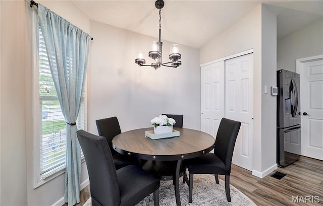 10 Warshire Ct Unit 67B, Ofallon, MO 63366 - dining room with a chandelier, wood finished floors, baseboards, and lofted ceiling