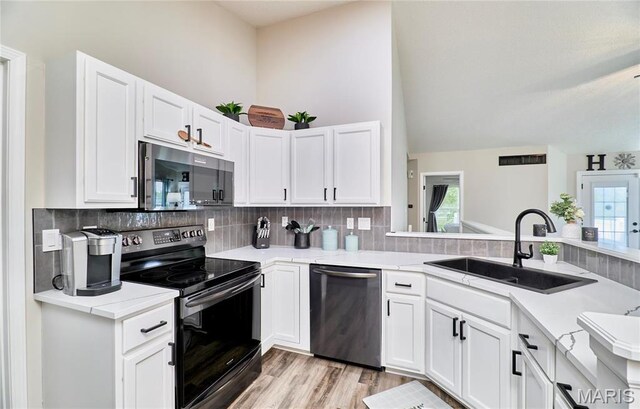 10 Warshire Ct Unit 67B, Ofallon, MO 63366 - kitchen with appliances with stainless steel finishes, a sink, tasteful backsplash, white cabinets, and high vaulted ceiling