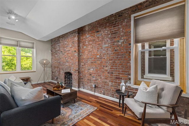 3318 Sidney St, Saint Louis, MO 63104 - living area featuring lofted ceiling, baseboards, wood finished floors, a brick fireplace, and brick wall