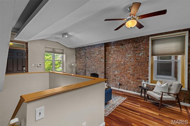 3318 Sidney St, Saint Louis, MO 63104 - interior space featuring brick wall, wood finished floors, baseboards, vaulted ceiling, and ceiling fan