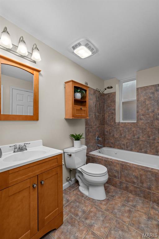3318 Sidney St, Saint Louis, MO 63104 - full bathroom featuring tiled shower / bath, toilet, vanity, and tile patterned flooring
