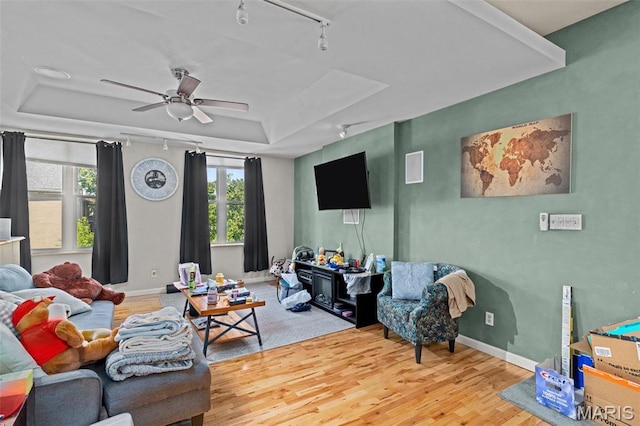 3318 Sidney St, Saint Louis, MO 63104 - living room with a tray ceiling, wood finished floors, rail lighting, ceiling fan, and baseboards