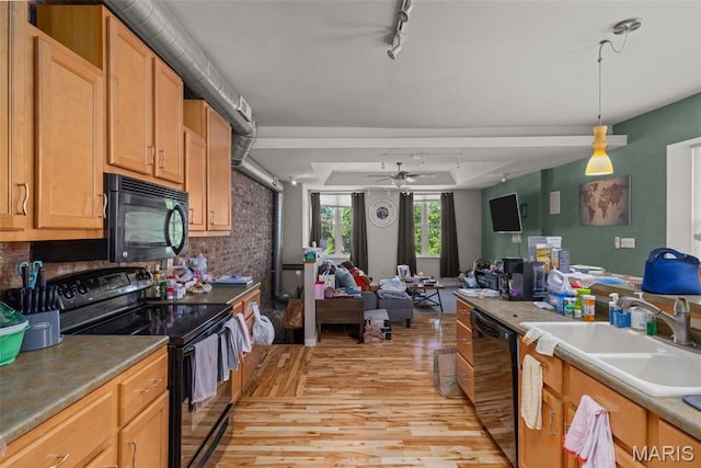 3318 Sidney St, Saint Louis, MO 63104 - kitchen with black appliances, a sink, light wood-style floors, track lighting, and decorative backsplash