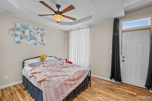 3318 Sidney St, Saint Louis, MO 63104 - bedroom with a tray ceiling, baseboards, light wood-style floors, and ceiling fan