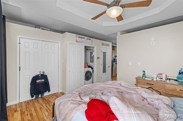 3318 Sidney St, Saint Louis, MO 63104 - bedroom with washer / clothes dryer, a raised ceiling, light wood finished floors, and ceiling fan