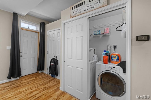 3318 Sidney St, Saint Louis, MO 63104 - laundry area with washing machine and dryer, light wood-style flooring, and baseboards