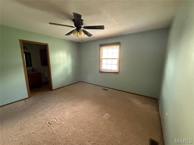 710 Ash St, Greenville, IL 62246 - spare room featuring baseboards, light carpet, a ceiling fan, and a textured ceiling