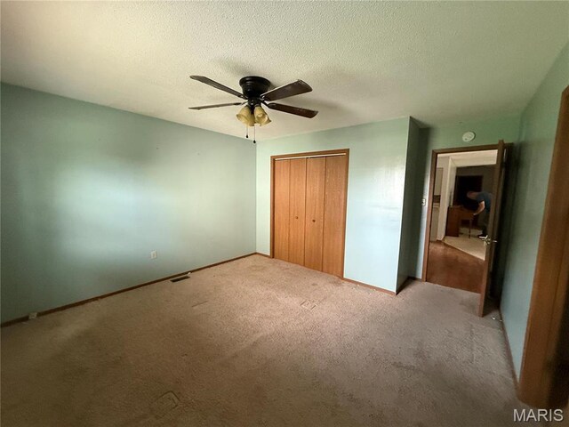 710 Ash St, Greenville, IL 62246 - unfurnished bedroom with carpet floors, a closet, a textured ceiling, and a ceiling fan