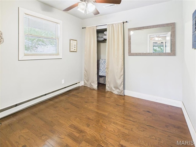 1 Richbark Ln, Van Buren, MO 63965 - unfurnished bedroom featuring multiple windows, wood finished floors, baseboards, and baseboard heating