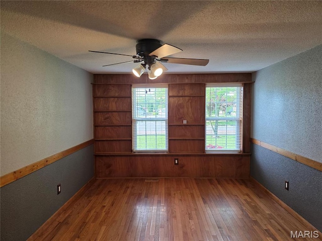 306 Edna Ln, Sparta, IL 62286 - spare room featuring a textured wall, hardwood / wood-style floors, baseboards, ceiling fan, and a textured ceiling