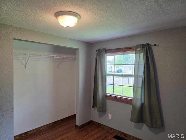 306 Edna Ln, Sparta, IL 62286 - unfurnished bedroom featuring dark wood-type flooring, a closet, a textured ceiling, and baseboards