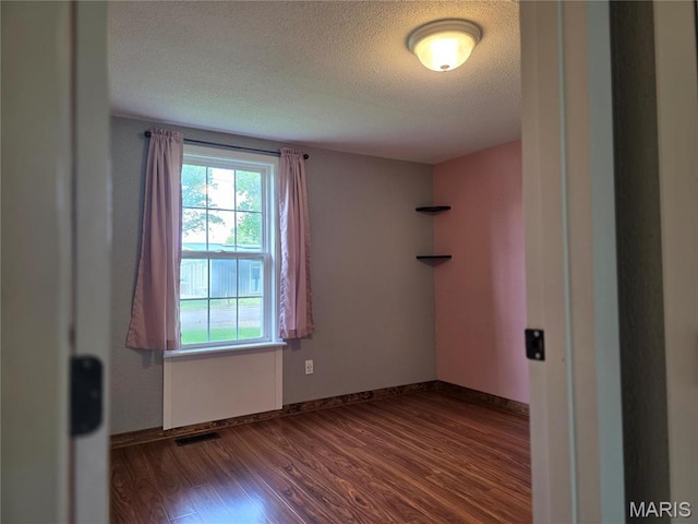 306 Edna Ln, Sparta, IL 62286 - empty room with dark wood-type flooring, a textured ceiling, and baseboards