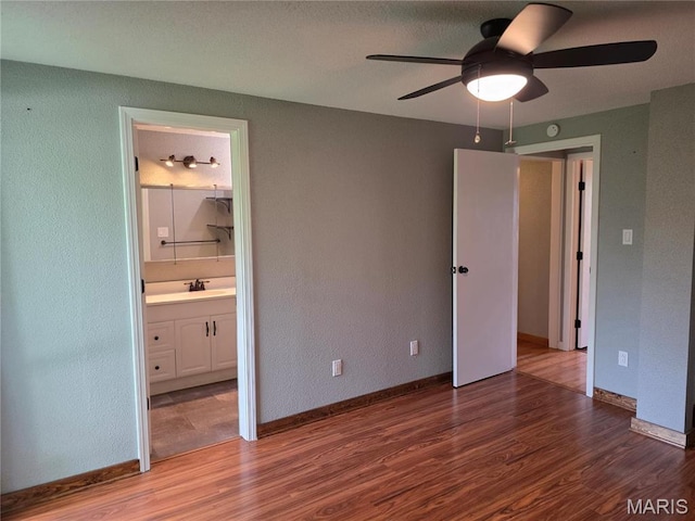 306 Edna Ln, Sparta, IL 62286 - unfurnished bedroom featuring wood finished floors, baseboards, ensuite bath, and a textured wall
