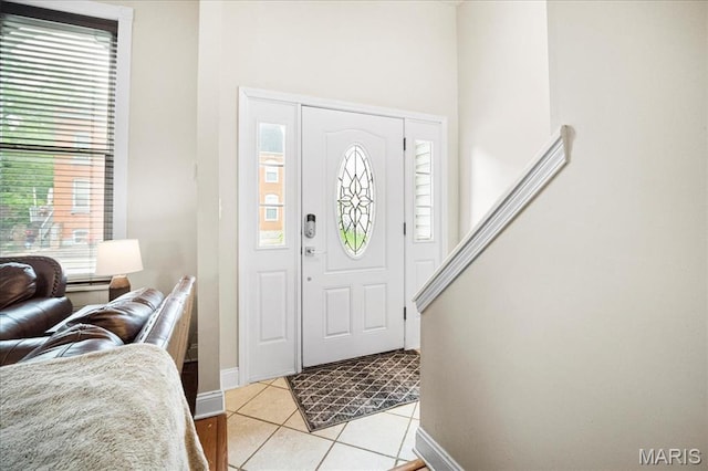 foyer entrance featuring plenty of natural light, baseboards, and light tile patterned floors