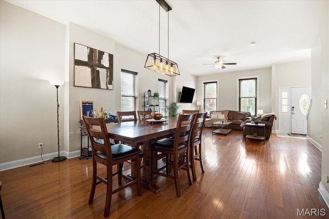 dining area with plenty of natural light, a ceiling fan, wood-type flooring, and baseboards