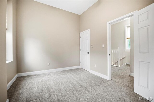 empty room featuring carpet and baseboards