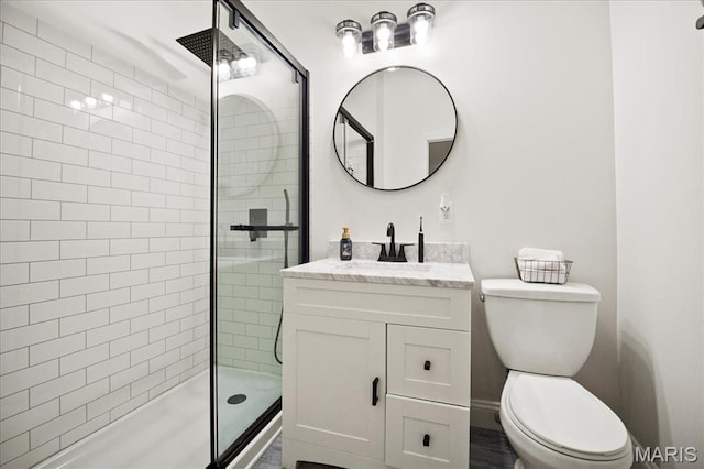 full bathroom with toilet, a shower stall, and vanity