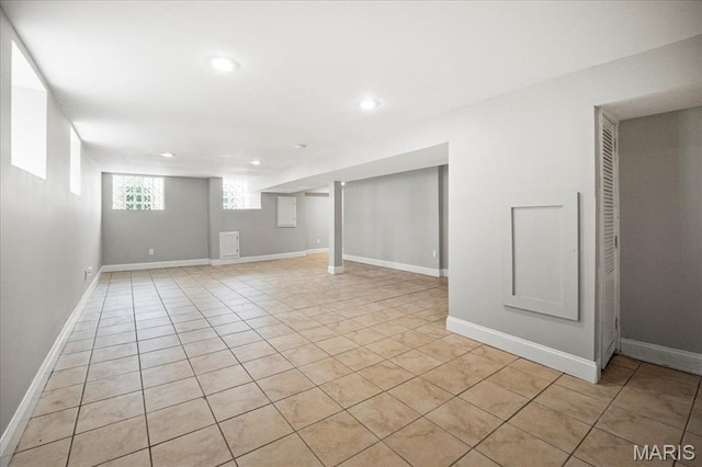 below grade area with recessed lighting, light tile patterned floors, and baseboards