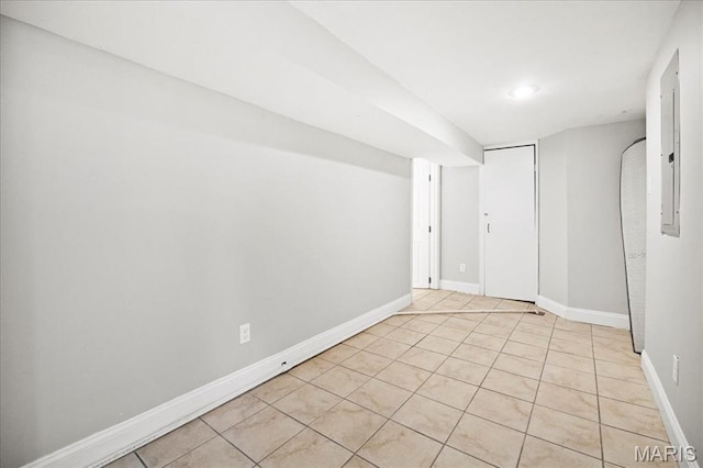 tiled spare room featuring baseboards