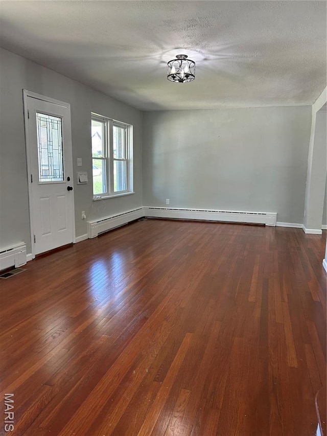 3604 Ridgedale Ave, Saint Louis, MO 63121 - foyer featuring dark wood finished floors, baseboards, a baseboard heating unit, and a textured ceiling