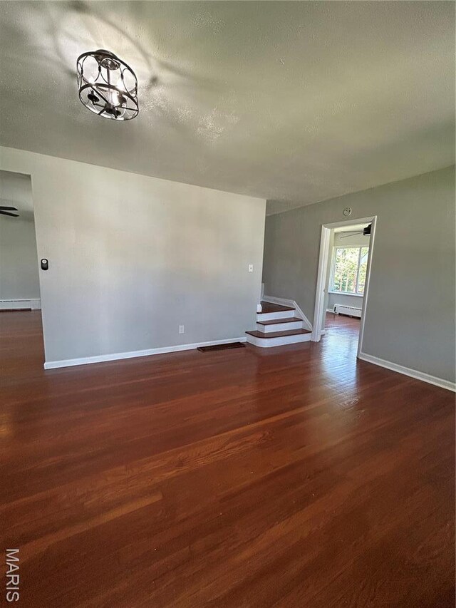 3604 Ridgedale Ave, Saint Louis, MO 63121 - unfurnished room featuring baseboards, dark wood-type flooring, baseboard heating, and a textured ceiling