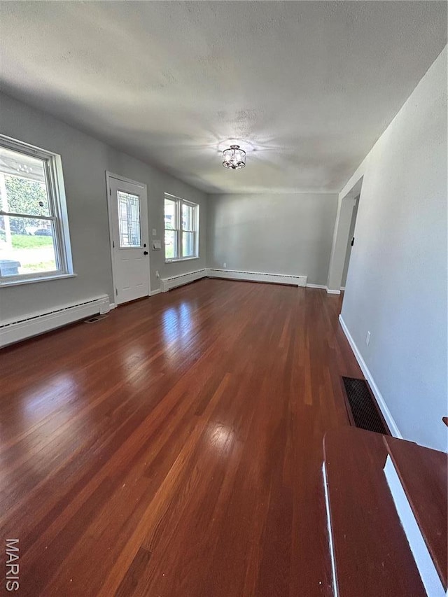 3604 Ridgedale Ave, Saint Louis, MO 63121 - unfurnished living room featuring wood finished floors, baseboards, a baseboard radiator, and a chandelier