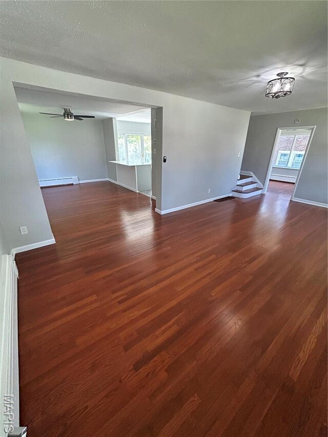 3604 Ridgedale Ave, Saint Louis, MO 63121 - unfurnished room featuring a baseboard radiator, stairs, wood finished floors, baseboards, and ceiling fan