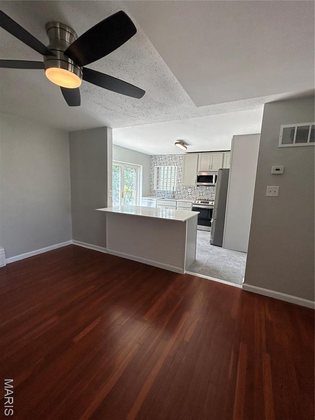3604 Ridgedale Ave, Saint Louis, MO 63121 - unfurnished living room with a ceiling fan, baseboards, light wood-style flooring, and a textured ceiling