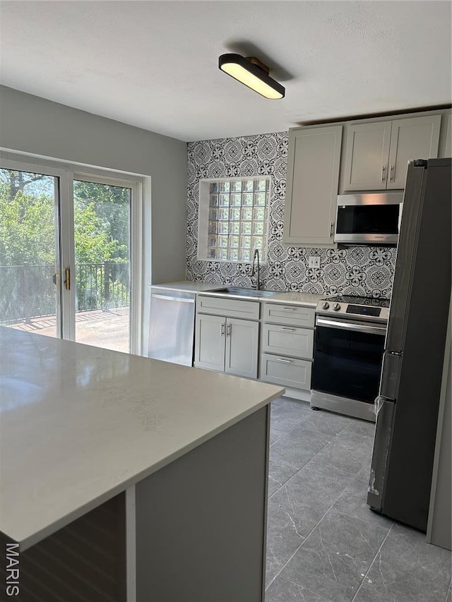 3604 Ridgedale Ave, Saint Louis, MO 63121 - kitchen featuring appliances with stainless steel finishes, a sink, light countertops, and plenty of natural light