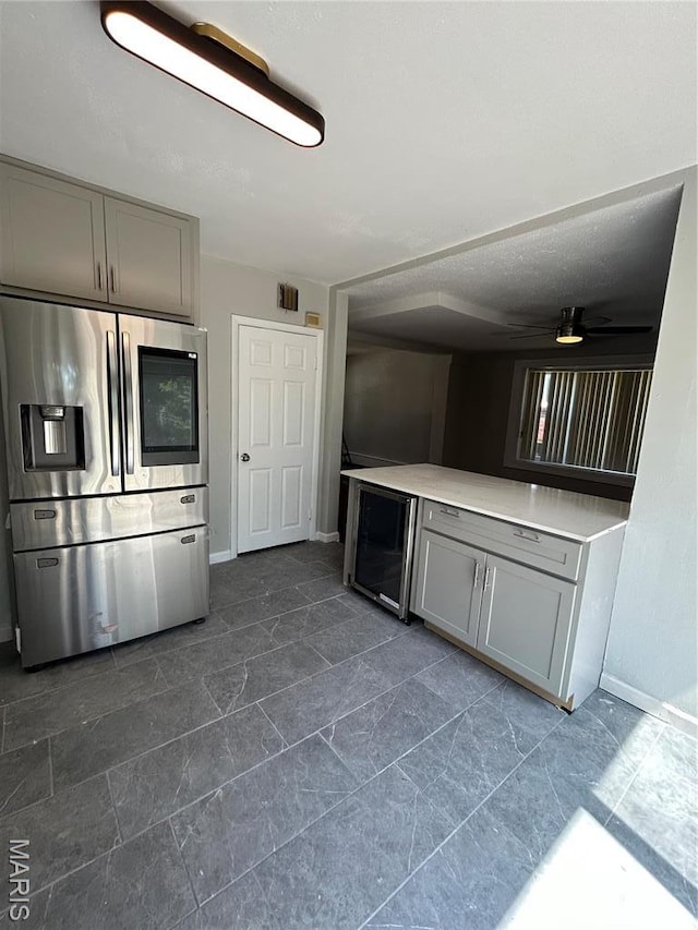 3604 Ridgedale Ave, Saint Louis, MO 63121 - kitchen featuring stainless steel fridge with ice dispenser, gray cabinets, wine cooler, a ceiling fan, and baseboards