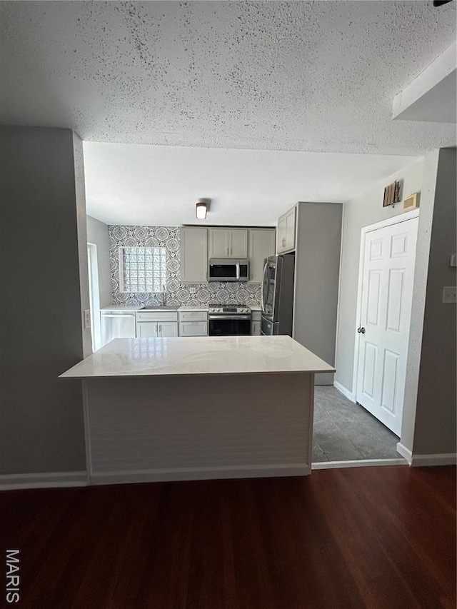 3604 Ridgedale Ave, Saint Louis, MO 63121 - kitchen featuring stainless steel appliances, light countertops, a sink, gray cabinets, and baseboards