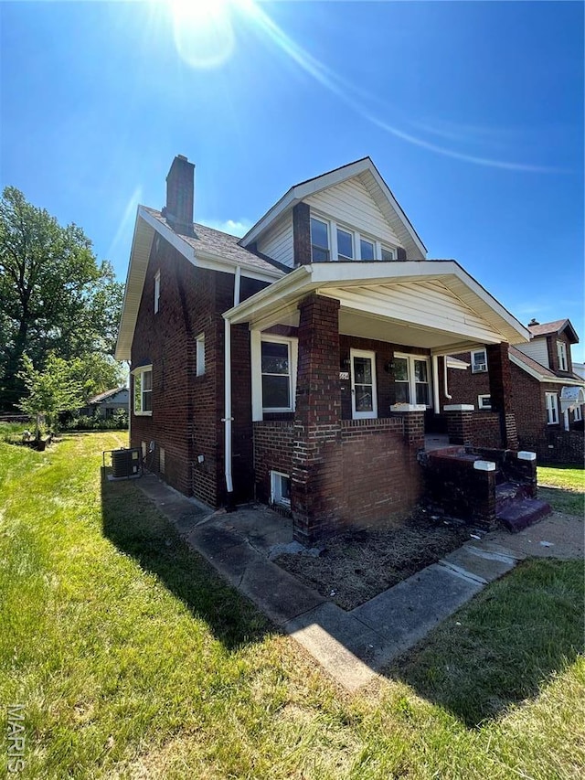 3604 Ridgedale Ave, Saint Louis, MO 63121 - view of front facade featuring a front lawn, a chimney, brick siding, and covered porch